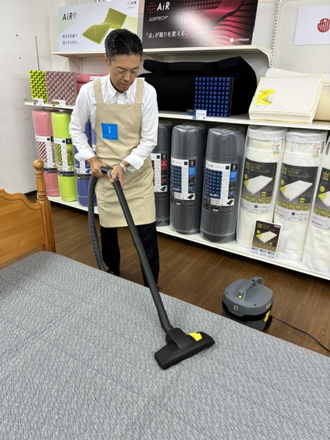 【画像：業務用掃除機での吸引】